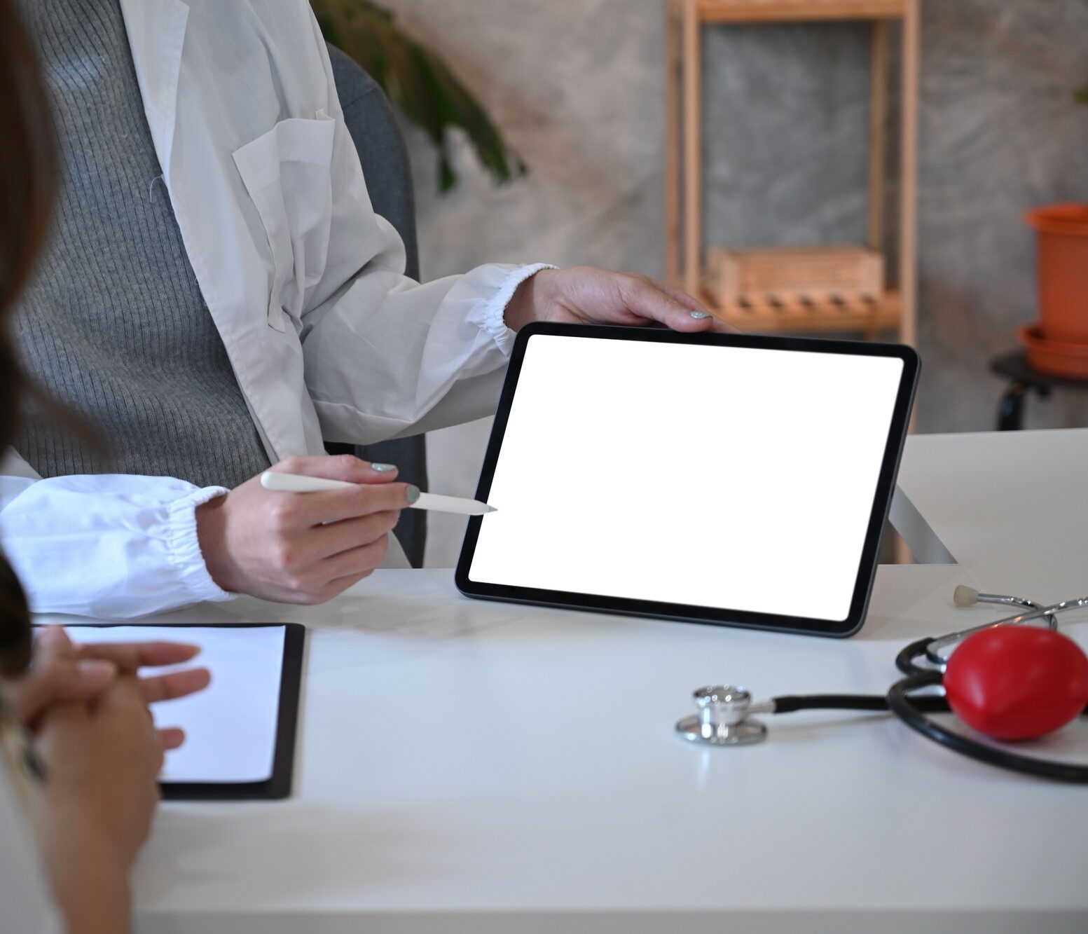 Cropped shot female doctor holding digital tablet and explaining medical informations to patient.
